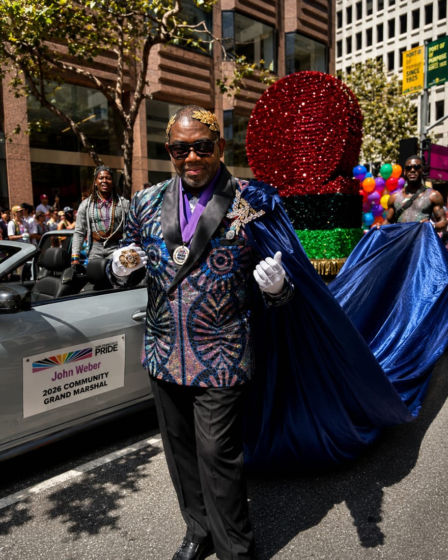 John Weber in a sequined jacket, gold laurel crown, medal and long blue cape beside his Grand Marshal car at the San Francisco Pride Parade